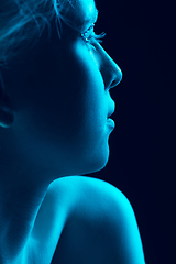 Image showing Portrait of beautiful albino girl isolated on dark studio background in neon light