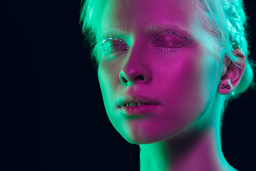 Image showing Portrait of beautiful albino girl isolated on dark studio background in neon light