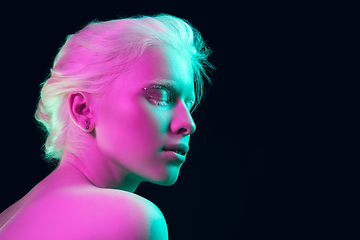 Image showing Portrait of beautiful albino girl isolated on dark studio background in neon light