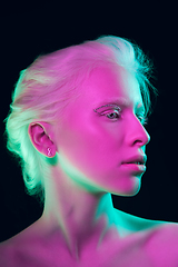 Image showing Portrait of beautiful albino girl isolated on dark studio background in neon light