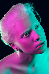 Image showing Portrait of beautiful albino girl isolated on dark studio background in neon light