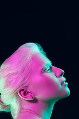 Image showing Portrait of beautiful albino girl isolated on dark studio background in neon light