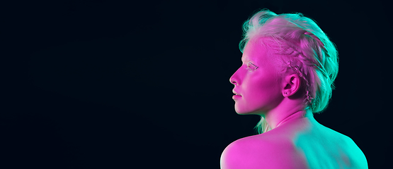 Image showing Portrait of beautiful albino girl isolated on dark studio background in neon light