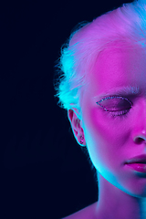 Image showing Portrait of beautiful albino girl isolated on dark studio background in neon light