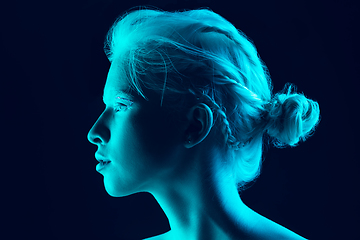 Image showing Portrait of beautiful albino girl isolated on dark studio background in neon light