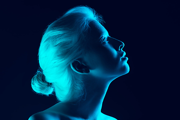 Image showing Portrait of beautiful albino girl isolated on dark studio background in neon light