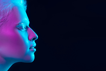 Image showing Portrait of beautiful albino girl isolated on dark studio background in neon light