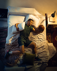 Image showing Top view of young professional basketball player sleeping at his bedroom in sportwear with ball