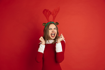 Image showing Beautiful woman like Christmas deer isolated on red background. Concept of 2021 New Year\'s, winter mood, holidays.