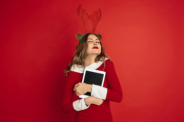 Image showing Beautiful woman like Christmas deer isolated on red background. Concept of 2021 New Year\'s, winter mood, holidays.