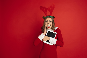 Image showing Beautiful woman like Christmas deer isolated on red background. Concept of 2021 New Year\'s, winter mood, holidays.