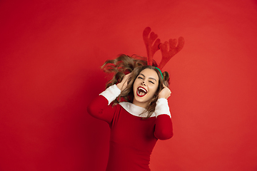 Image showing Beautiful woman like Christmas deer isolated on red background. Concept of 2021 New Year\'s, winter mood, holidays.