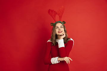 Image showing Beautiful woman like Christmas deer isolated on red background. Concept of 2021 New Year\'s, winter mood, holidays.