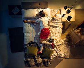 Image showing Top view of young professional football, soccer player sleeping at his bedroom in sportwear with ball