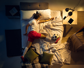 Image showing Top view of young professional football, soccer player sleeping at his bedroom in sportwear with ball