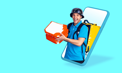 Image showing Handsome delivery man giving order right from smartphone\'s screen, fast delivery concept