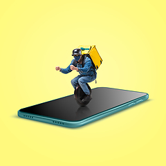 Image showing Handsome delivery man giving order right from smartphone\'s screen, fast delivery concept