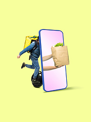 Image showing Handsome delivery man giving order right from smartphone\'s screen, fast delivery concept