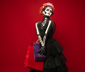 Image showing Young girl in the image of Santa Muerte, Saint death or Sugar skull with bright make-up. Portrait isolated on studio background.