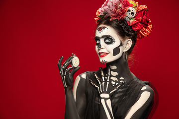 Image showing Young girl in the image of Santa Muerte, Saint death or Sugar skull with bright make-up. Portrait isolated on studio background.