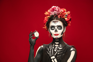 Image showing Young girl in the image of Santa Muerte, Saint death or Sugar skull with bright make-up. Portrait isolated on studio background.