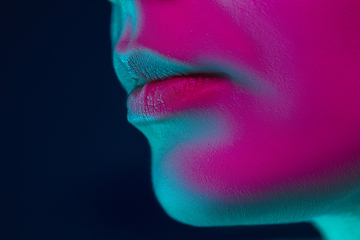 Image showing Close up portrait of female fashion model in neon light on dark studio background.