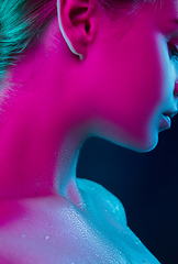 Image showing Close up portrait of female fashion model in neon light on dark studio background.