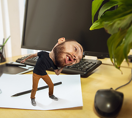 Image showing Tired man, office worker holding his huge tired head, funny