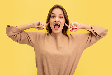 Image showing Portrait of young caucasian woman with bright emotions isolated on yellow studio background