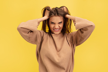 Image showing Portrait of young caucasian woman with bright emotions isolated on yellow studio background