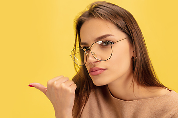 Image showing Portrait of young caucasian woman with bright emotions isolated on yellow studio background