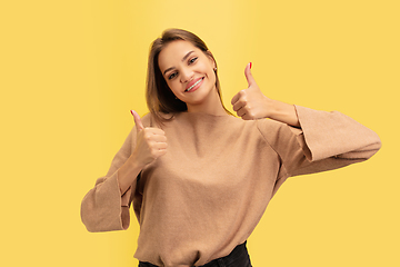 Image showing Portrait of young caucasian woman with bright emotions isolated on yellow studio background