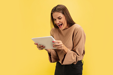 Image showing Portrait of young caucasian woman with bright emotions isolated on yellow studio background