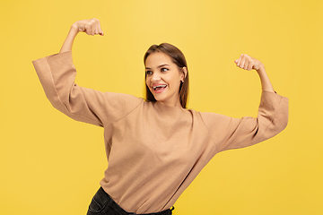 Image showing Portrait of young caucasian woman with bright emotions isolated on yellow studio background