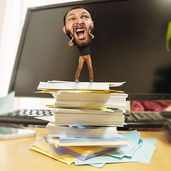 Image showing Tired man, office worker holding his huge tired head, funny