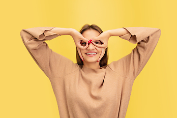 Image showing Portrait of young caucasian woman with bright emotions isolated on yellow studio background