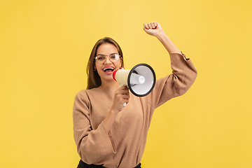 Image showing Portrait of young caucasian woman with bright emotions isolated on yellow studio background