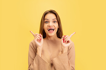 Image showing Portrait of young caucasian woman with bright emotions isolated on yellow studio background