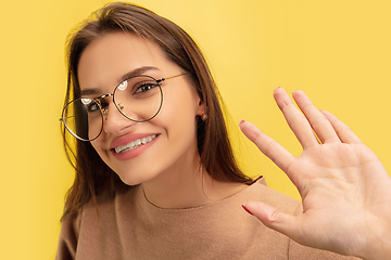 Image showing Portrait of young caucasian woman with bright emotions isolated on yellow studio background