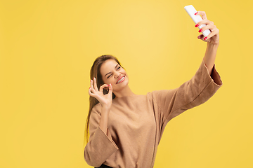 Image showing Portrait of young caucasian woman with bright emotions isolated on yellow studio background