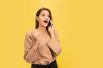 Image showing Portrait of young caucasian woman with bright emotions isolated on yellow studio background