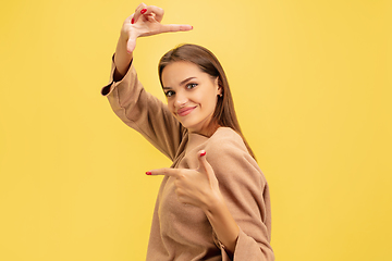 Image showing Portrait of young caucasian woman with bright emotions isolated on yellow studio background