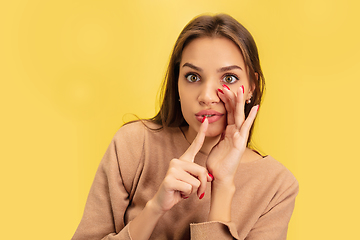 Image showing Portrait of young caucasian woman with bright emotions isolated on yellow studio background