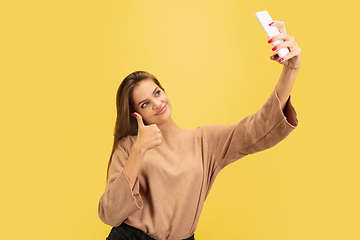 Image showing Portrait of young caucasian woman with bright emotions isolated on yellow studio background