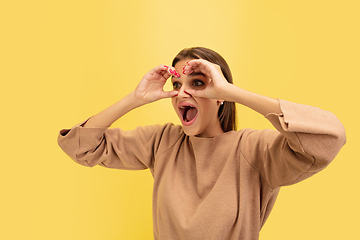 Image showing Portrait of young caucasian woman with bright emotions isolated on yellow studio background