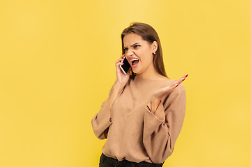 Image showing Portrait of young caucasian woman with bright emotions isolated on yellow studio background