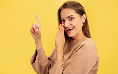 Image showing Portrait of young caucasian woman with bright emotions isolated on yellow studio background