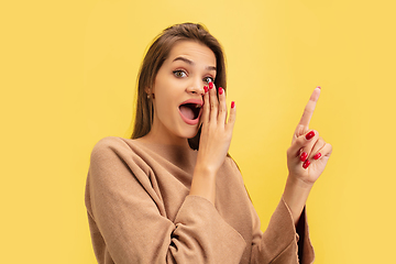 Image showing Portrait of young caucasian woman with bright emotions isolated on yellow studio background