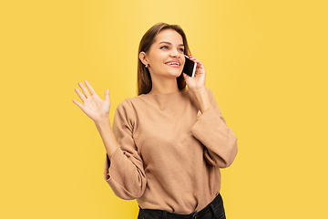 Image showing Portrait of young caucasian woman with bright emotions isolated on yellow studio background