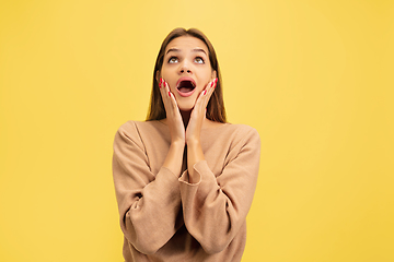 Image showing Portrait of young caucasian woman with bright emotions isolated on yellow studio background